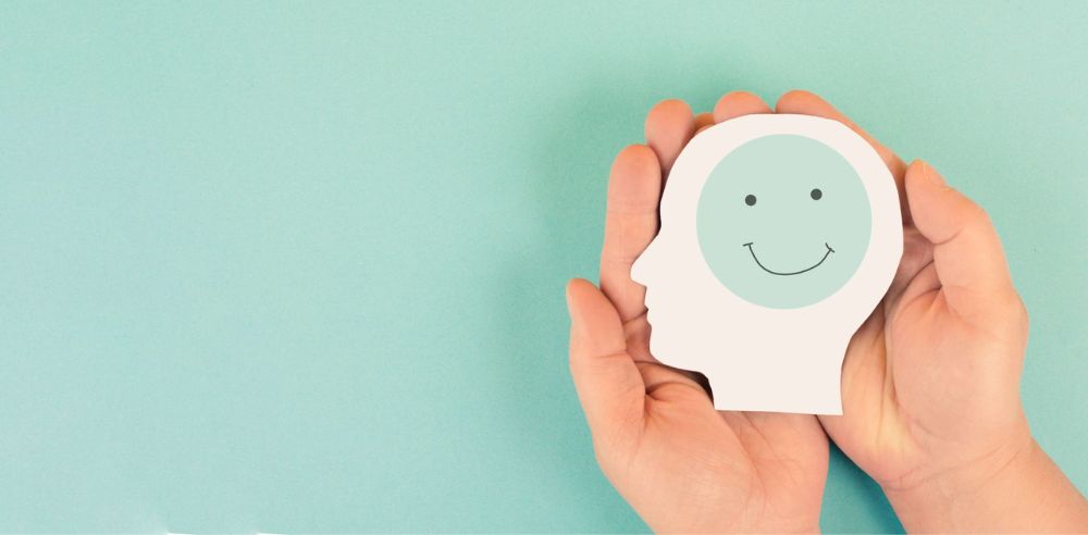 Holding a head with a happy smiling face in the hands