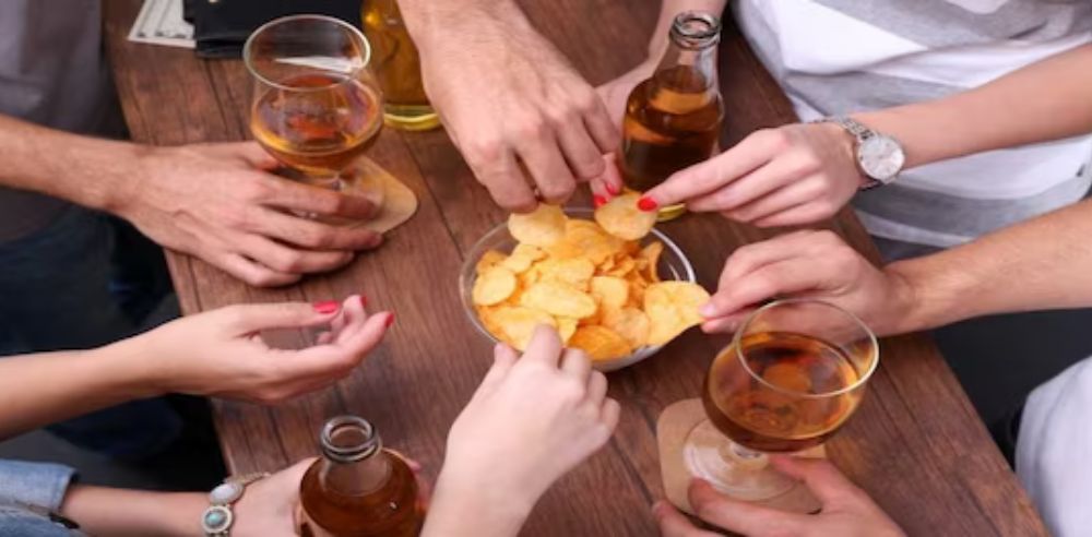 Friends having alcoholic drinks and wine chips in the bar 