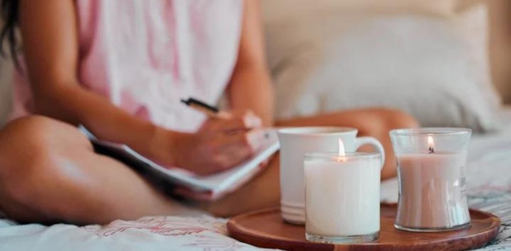 Woman writing with home candles