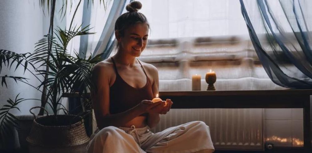 Young woman sitting on the floor doing yoga exercise at home